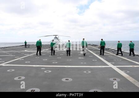 Océan Pacifique (Juin 21, 2018) - La maintenance de test à l'air et de l'évaluation (1 Escadron VX-1) inspecter l'envol de l'indépendance la variante de combat littoral USS Coronado (LCS) 4 pour un objet étranger et de débris en vue de lancer un MQ-8C Fire Scout pour l'essai en cours. Le MQ-8C Fire Scout est le plus récent de la Marine et de l'hélicoptère sans pilote a augmenté la vitesse, un plafond plus élevé, plus de deux fois plus de carburant, l'endurance et l'amélioration de la capacité de charge par rapport aux versions antérieures. LCS est un haut-débit, agile, faible tirant d'eau, axée sur la mission de combat de surface conçu pour des opérations dans le littoral e Banque D'Images