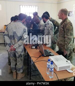 BASE D'OPÉRATION AVANCÉE THUNDER, Gardez, Afghanistan -- l'Armée nationale afghane et de la Force à la frontière afghane des explosifs et des munitions (NEM) soldats regarder un instructeur réparer la MMP-30 robot NEM au cours d'un entretien et de la réparation de l'opérateur robotique cours, du 25 au 28 juin. Les élèves ont appris comment résoudre les problèmes et effectuer la réparation de base des robots utilisés par les soldats de NEM à enquêter et à désarmer des dispositifs explosifs de circonstance. Banque D'Images