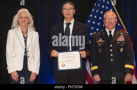 Tom Reynolds, qui gère la valeur de génie à Redstone Arsenal, accepte un Ministère de la Défense l'ingénierie de la valeur Prix au nom de l'Aviation and Missile Command dans la catégorie organisation au cours d'une cérémonie de remise des prix le 28 juin au Pentagone. C'est la troisième année consécutive qu'AMCOM a remporté le prix de l'organisation. Cette année, le prix reconnaît l'achèvement de 98 projets d'ingénierie de la valeur représentant 216 millions de dollars sur une période de trois ans. Présenter le prix de Reynolds sont Kristen Baldwin, secrétaire adjoint par intérim de la défense de l'ingénierie des systèmes, et le Maj Banque D'Images