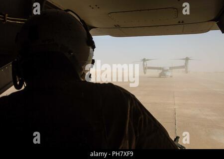 L'Iraq (15 juin 2018) Un chef d'équipe des marines observe une MV-22B Osprey taxi en ligne de vol lors d'une mission de ravitaillement à l'appui de la Force opérationnelle interarmées - Fonctionnement résoudre inhérents (GFIM-OIR) à Al Asad Air Base, l'Iraq, le 15 juin 2018. Les GFIM-OIR est le bras militaire de la Coalition mondiale pour vaincre ISIS dans des zones désignées de l'Iraq et la Syrie. Banque D'Images