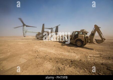 L'Iraq (15 juin 2018) les chefs d'équipage de la Marine américaine de décharger la cargaison de la rampe arrière d'un MV-22B Balbuzard au cours d'une mission de ravitaillement à l'appui de la Force opérationnelle interarmées - Fonctionnement résoudre inhérents (GFIM-OIR) à Firebase Um Jorais, l'Iraq, le 15 juin 2018. Les GFIM-OIR est le bras militaire de la Coalition mondiale pour vaincre ISIS dans des zones désignées de l'Iraq et la Syrie. Banque D'Images