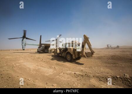 L'Iraq (15 juin 2018) les chefs d'équipage de la Marine américaine de décharger la cargaison de la rampe arrière d'un MV-22B Balbuzard au cours d'une mission de ravitaillement à l'appui de la Force opérationnelle interarmées - Fonctionnement résoudre inhérents (GFIM-OIR) à Firebase Um Jorais, l'Iraq, le 15 juin 2018. Les GFIM-OIR est le bras militaire de la Coalition mondiale pour vaincre ISIS dans des zones désignées de l'Iraq et la Syrie. Banque D'Images