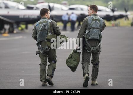 Le capitaine de l'US Air Force Philip Huebner, prochaine formation pilote pilote instructeur, lieutenant Chase et Todd, PTN étudiant, parlent de leur vol d'entraînement, comme ils l'étape de l'avion à l'aéroport international Austin-Bergstrom à Austin, Texas, le 22 juin 2018. PTN est un commandement d'éducation et de formation visant à explorer et éventuellement un prototype d'environnement de formation qui intègre différentes technologies pour produire des pilotes dans un rythme accéléré, à faible coût, de l'apprentissage. Le programme de six mois s'appuie sur une variété de technologies, d'inclure réalité virtuelle et augmentée, la biométrie, l'avancée Banque D'Images