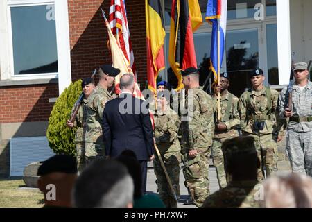 Le colonel de l'armée américaine Sean H. Kuester, nouveau commandant de l'unité, renvoie le commandement de l'Armée de couleurs pour le Sgt. Le major Samara L. Pitre au cours de la garnison de l'armée américaine Passation de commandement du Benelux : Caserne Daumerie dans Chièvres, Belgique, le 29 juin 2018. Banque D'Images