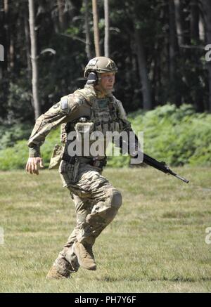 Le Sgt. 1re classe Paul Deugan, tous les membres de l'équipe de combat international de protection de l'Iowa Army National Guard, des sprints de 300 mètres à l'firingline aux cibles engate 100-300 mètres au cours de la Défense du Royaume-Uni 2018 Concours de tir opérationnel qui a eu lieu joinly à Bisley Camp et le Centre de formation de la réserve de l'Armée de Pirbright, en Angleterre au cours du mois de juin 12-26, 2018. Banque D'Images