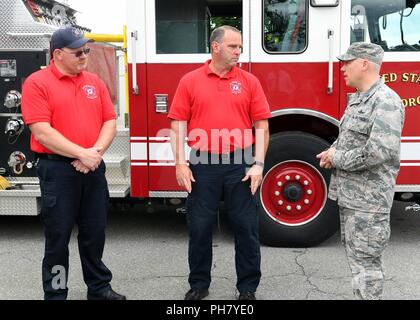 Le colonel Roman Hund, commandant de l'installation des pièces, Keith Williams, à gauche, et Vincent Sanchez Hanscom, pompiers, à l'extérieur le service d'incendie à Hanscom Air Force Base, Mass., 15 juin. Le commandant a inventé pour la formation dont ils ont fourni le mois dernier pour lui. Banque D'Images