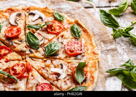 Composition de pizza savoureuse décoré de feuilles de basilic Banque D'Images