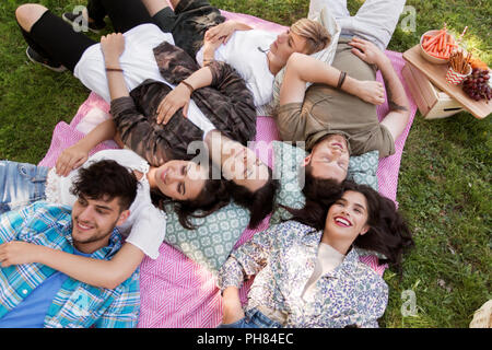 Happy friends refroidissement sur couverture de pique-nique à l'été Banque D'Images