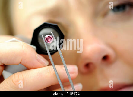 Un employé regarde à travers une loupe à un diamant rose extrêmement rare à la Rio Tinto Diamonds bureau à Tokyo, Japon, le lundi 22 septembre 2008. Photographie Banque D'Images