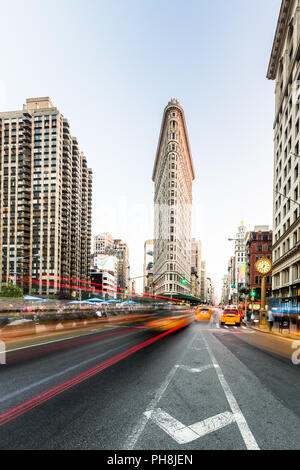 NEW YORK CITY USA - 24 août 2014 : Motion blurred traffic en face de l'Flatiron building à la Cinquième Avenue à Manhattan. Est un établissement emblématique Flatiron bui Banque D'Images