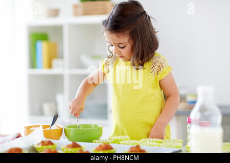 Petite fille confectionner des muffins à la maison Banque D'Images