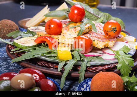 Ensemble prédéfini de fromage et des collations. Halloumi grillé, belper knolle de sauce sur fond bleu fond noir. Banque D'Images