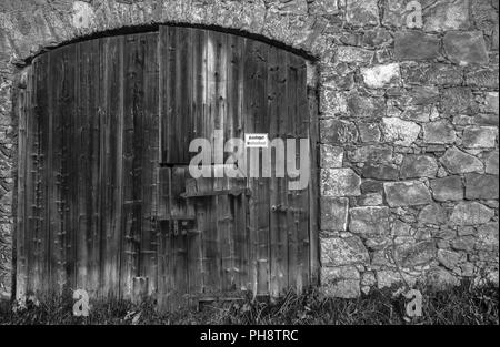 Ancienne grange gate avec mur de fondation Banque D'Images