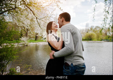 Jeune couple dans l'amour à l'extérieur. Rire et huggs contexte lake Banque D'Images