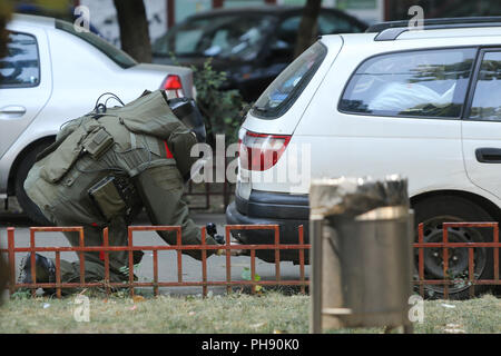 Bucarest, Roumanie - 31 août 2018 : Artificier en combinaison antibombe pour l'élimination des explosifs et munitions (NEM) est la vérification d'une voiture suspecte dans une rue je Banque D'Images