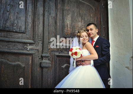 Wedding couple sur l'arrière-plan de la vieille porte en bois Banque D'Images