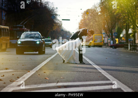 Kissing wedding couple au milieu de la route Banque D'Images