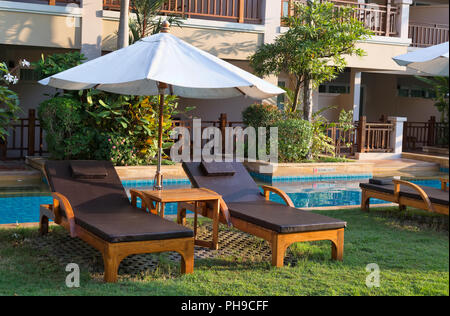 Des chaises longues au bord de la piscine Banque D'Images