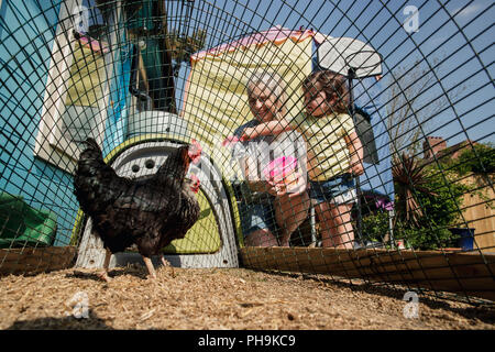 Portrait d'une petite fille était avec sa grand-mère l'alimentation des poulets. Ils sont se tenait dans le jardin arrière au poulailler tomber chicke Banque D'Images