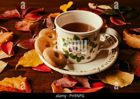 Tasse de thé avec des biscuits et du feuillage d'automne Banque D'Images