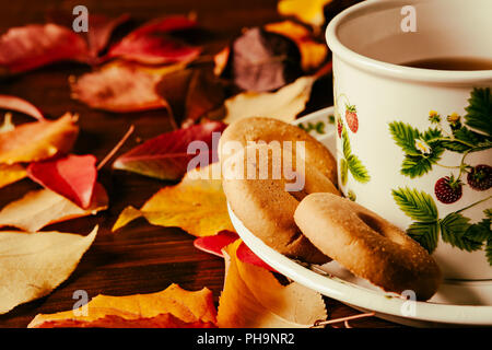 Libre de tasse de thé avec des biscuits et du feuillage d'automne Banque D'Images