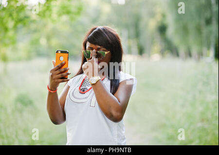 Noir élégant african american woman faire sur son téléphone selfies Banque D'Images