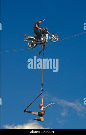 Moto stunt rider sur fil avec girl acrobat Albert Park Melbourne Australie Victoria Banque D'Images