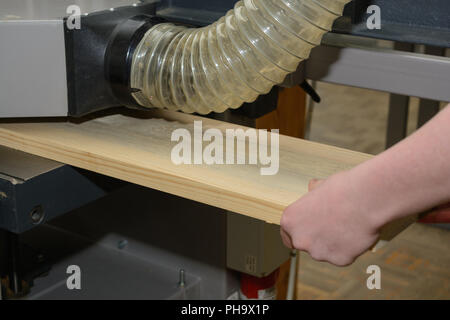 Carpenter panneaux de bois sur une machine de rabotage - close-up Banque D'Images