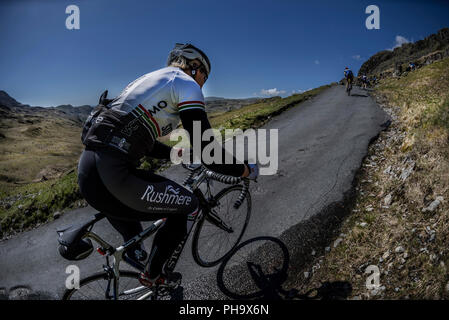 Randonnées cycliste féminin Hardknott Pass dans le Fred Whitton Challenge, Cumbria, Royaume-Uni. Banque D'Images