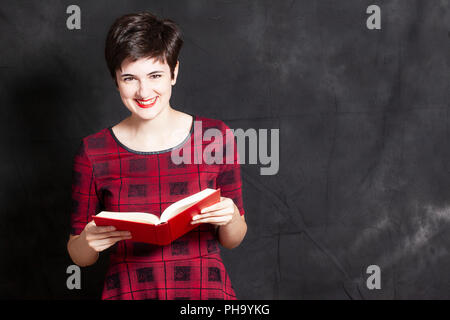 Heureux jeune adolescent lit un livre Banque D'Images