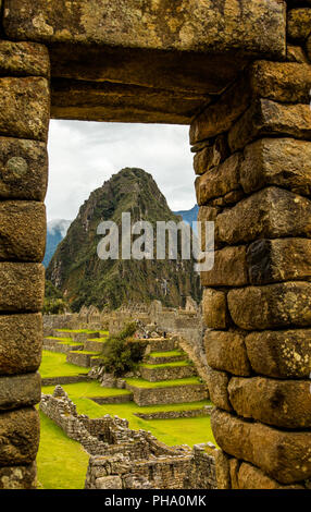 La montagne Huayna Picchu et le complexe de logements en usine à partir d'une porte dans le Palais Royal. Machu Picchu, Pérou Banque D'Images