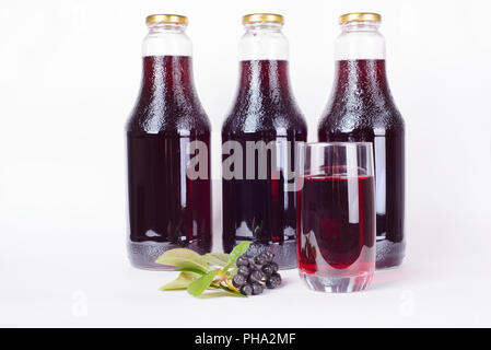 Bouteilles de sirop fait de l'aronie et verre
