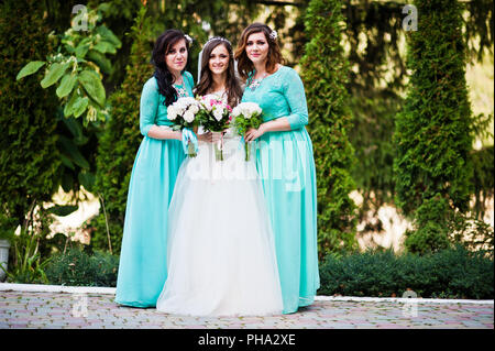 Mariée avec demoiselles sur eau turquoise robes outdoor Banque D'Images