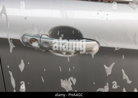 Une vue rapprochée de mousse de savon sur la poignée de porte d'une voiture d'argent Banque D'Images