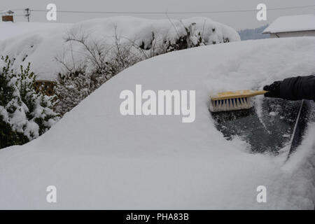 Neige profonde voiture est libéré de la neige avec l'aide d'un fouet Banque D'Images