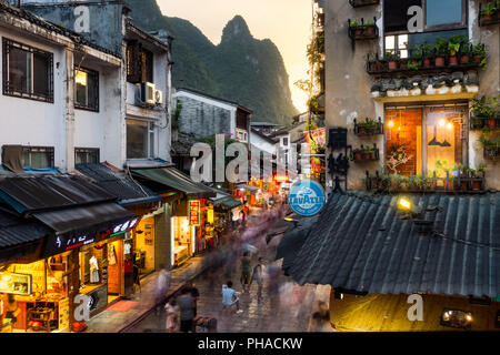 YANGSHUO, Chine Août 2018 : Yangshuo Western Street occupé au coucher du soleil avec des gens animés Banque D'Images