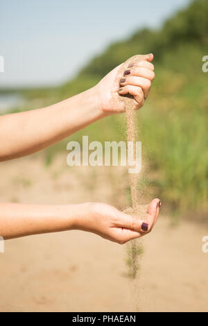 Dans sable mains de femme dans la plage Banque D'Images