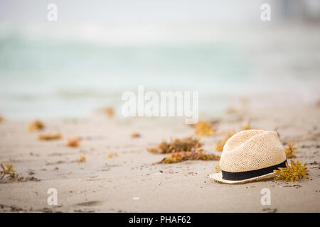 Chapeau de paille de Nice portant sur le sable. Belle plage sur l'océan. À l'extérieur. Temps de vacances. Fin de vacances d'été. Vous rêvez de vacances à la mer Banque D'Images