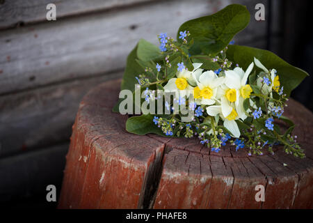 Beau bouquet de fleurs de jardin portant sur le fond de bois. Bouquet de printemps ne m'oubliez pas, narcisses, jonquilles et de feuilles. Fleurs d'été. Banque D'Images