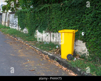 Les bacs jaunes sont placés sur le côté de la route dans le village. La corbeille est pour les gens dans le village pour la poubelle de gauche en attente de tri pour recyc Banque D'Images