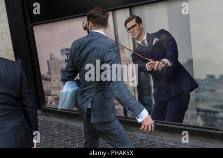 Les Londoniens passent devant une affiche présentant un homme d'affaires bénéficiant de temps libre sur le cours de golf portant un costume bleu - a favorisé le style et la couleur de l'homme dans la ville de Londres, le quartier financier de la capitale - aka le Square Mile, le 29 août 2018, à Londres, en Angleterre. Banque D'Images