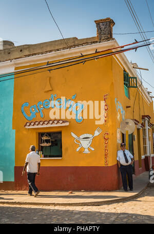 Trinidad, Cuba / 15 mars 2016 : l'homme s'appuie contre Cuba café coin coloré murale peinte avec à l'UNESCO du patrimoine de la ville. Banque D'Images