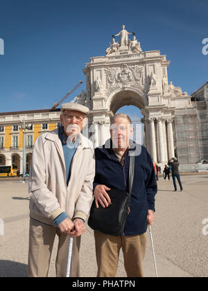 Portugal, Lisbonne, vieux et aveugle les touristes à Praca do Comercio avec le ministère de la Justice et de l'Arco da Rua Agusta derrière Banque D'Images