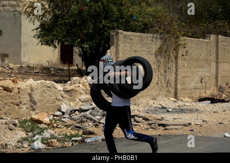 31 août 2018 - Les enfants palestiniens et les adolescents en conflit avec les forces de sécurité israéliennes au cours d'une manifestation hebdomadaire dans la ville cisjordanienne de Kafr Qaddum contre la confiscation de terres et la fermeture de la route principale de la ville. La question d'Israël cesse de s'emparer de terres pour construire ou étendre les colonies de peuplement israéliennes en Cisjordanie est un obstacle majeur à la réalisation d'un accord de paix entre Palestiniens et Israéliens. Les habitants de Kafr Qaddum ont été manifestation hebdomadaire depuis 2011 pour protester contre l'extension de la colonie israélienne de Kadumin, t Banque D'Images