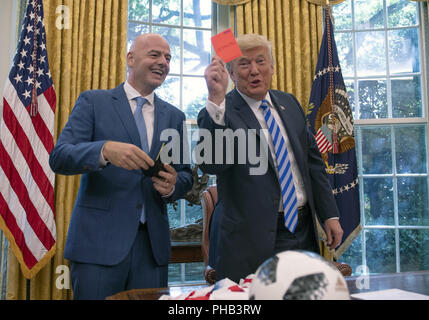 Washington, District de Columbia, Etats-Unis. Août 28, 2018. Le Président des Etats-Unis, Donald J. Trump, droit, est titulaire d'une carte rouge de mort qui a été présenté à lui par Gianni Infantino, gauche, Président de la Fédération Internationale de Football Association (FIFA) au cours d'une réunion pour discuter de la Coupe du Monde 2026 en Amérique du Nord dans le bureau ovale de la Maison Blanche. Credit : Ron Sachs/CNP/ZUMA/Alamy Fil Live News Banque D'Images