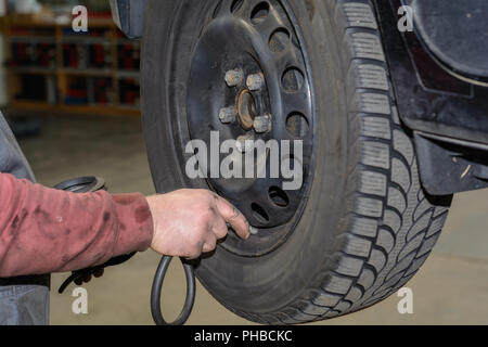 La pression des pneus Contrôle de mécanicien avec compresseur d'air Banque D'Images