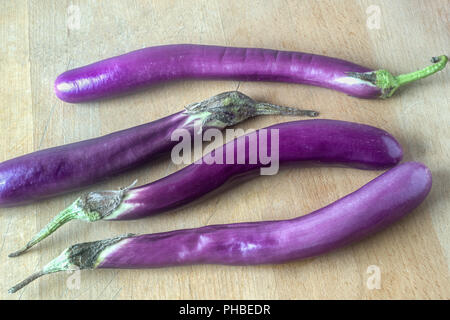 Les aubergines japonaises sur une planche en bois Banque D'Images