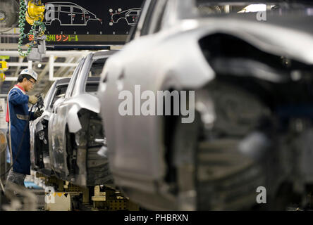 Un ouvrier travaille sur un véhicule à Nissan Motor Co.s usine de montage à Tochigi, au Japon le jeudi 12 novembre 2009. Photographe : Robert Gilhooly Banque D'Images