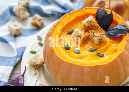 Soupe au potiron avec des croûtons dans un gros plan de la citrouille. Banque D'Images