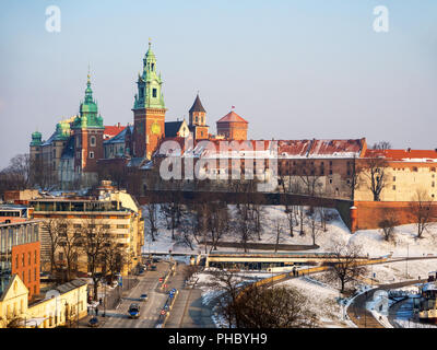 Cracovie, Pologne. La cathédrale du Wawel et le château en hiver avec de la neige, de la rivière Vistule banque et hôtels. Aerioal voir le coucher du soleil dans la lumière. Banque D'Images